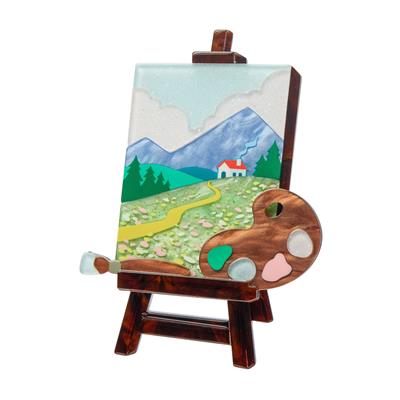 Miniature wooden easel with a painted landscape scene on a white background