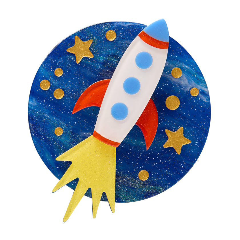 Colorful Erstwilder Brooch a rocket ship against a space-themed background with stars and planets.