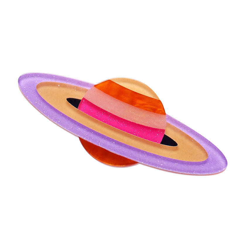 Erstwilder Brooch resembling a planet with colorful rings on a white background