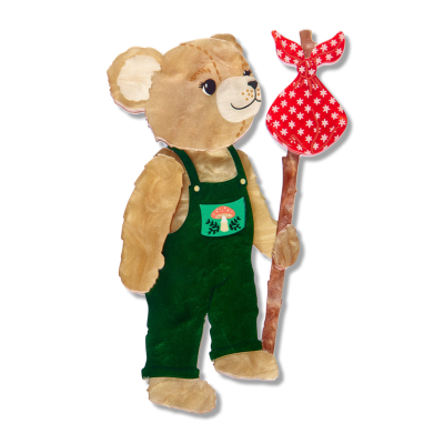 teddy bear in green overalls holding a red and white striped sack on the end of a carry stick on a white background