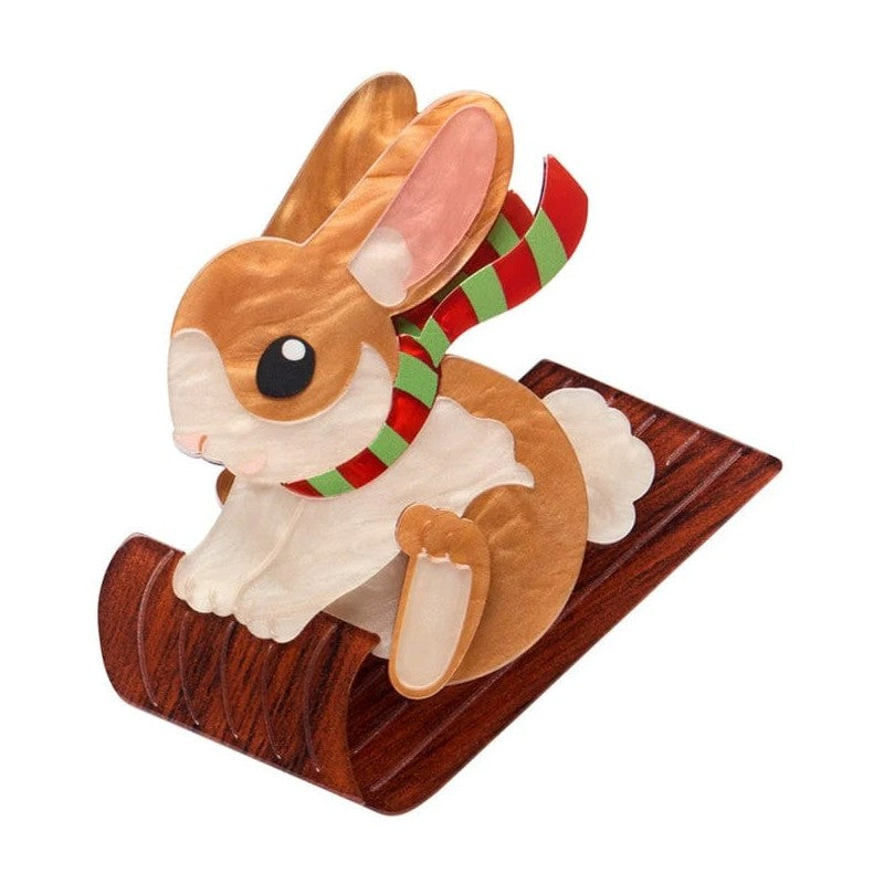 rabbit on Toboggan with a red and green striped scarf on a white background