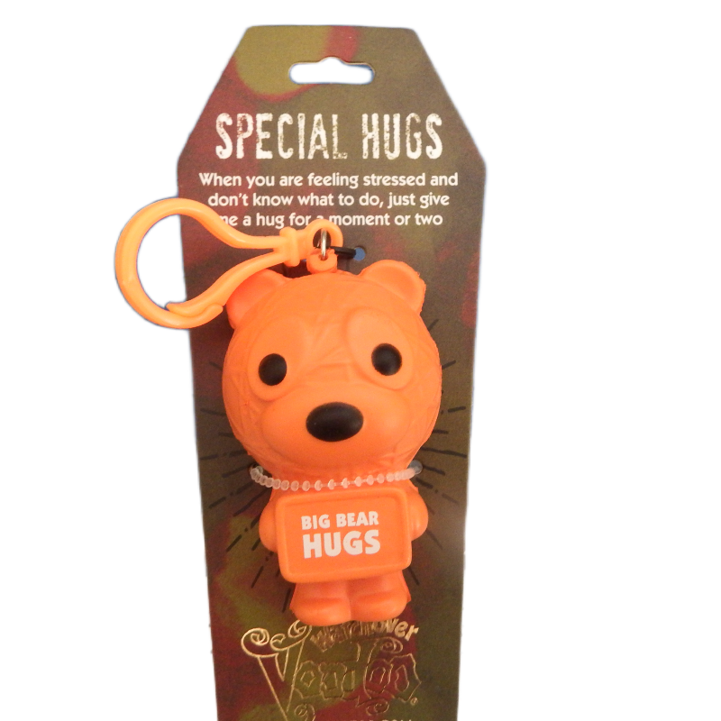 Orange bear-shaped keychain with 'Big Bear Hugs' text on a brown packaging background.