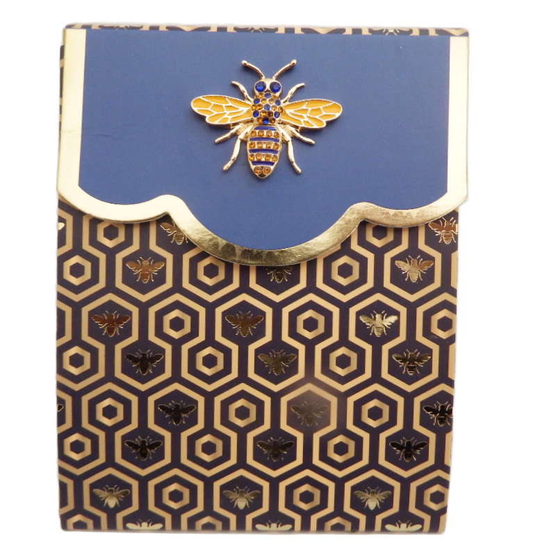 Notebook with bee design on blue cover and gold patterned cover
