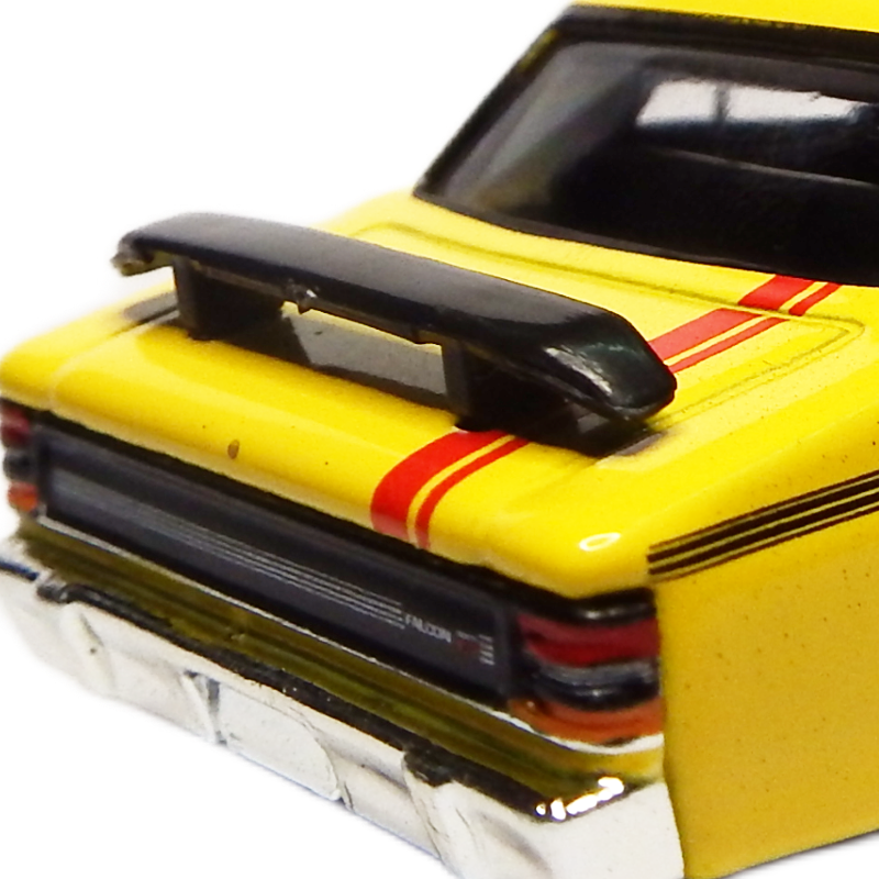 Yellow model car with black spoiler and red stripes on a white background