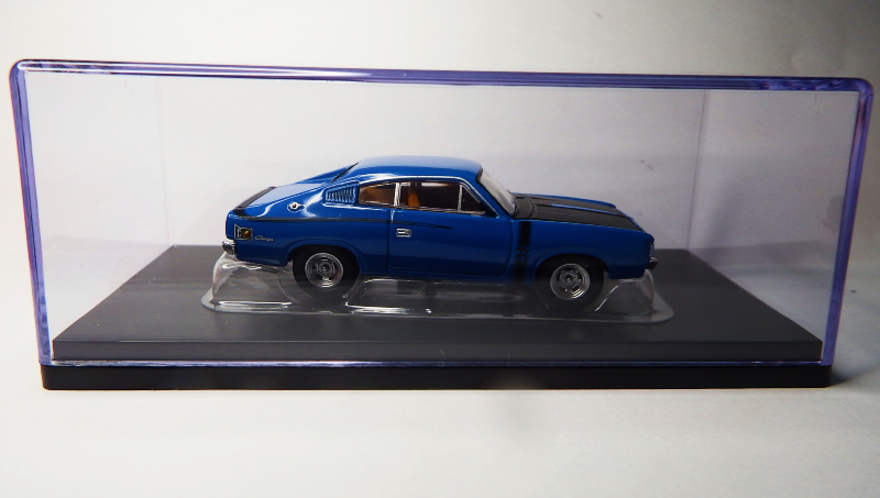 Blue model car in a clear display case on a white background