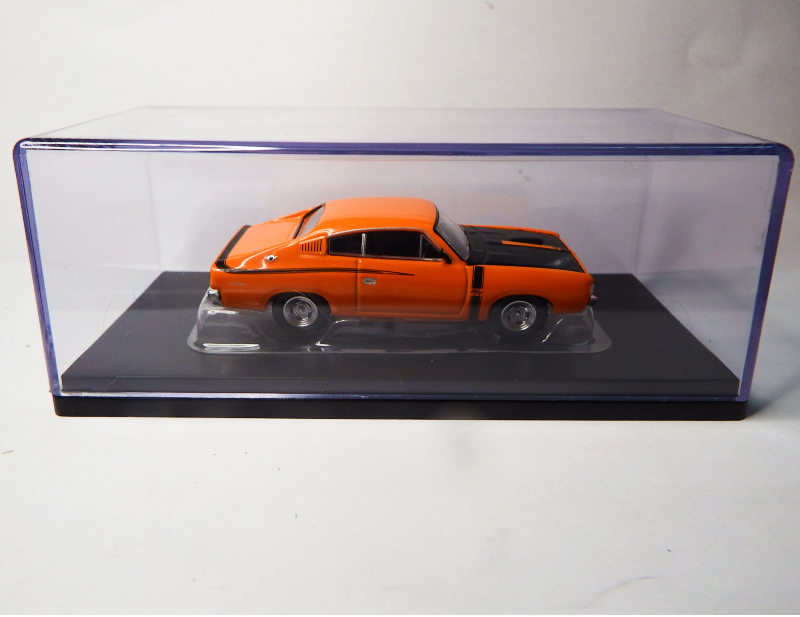 Orange model car in a clear display case on a white background