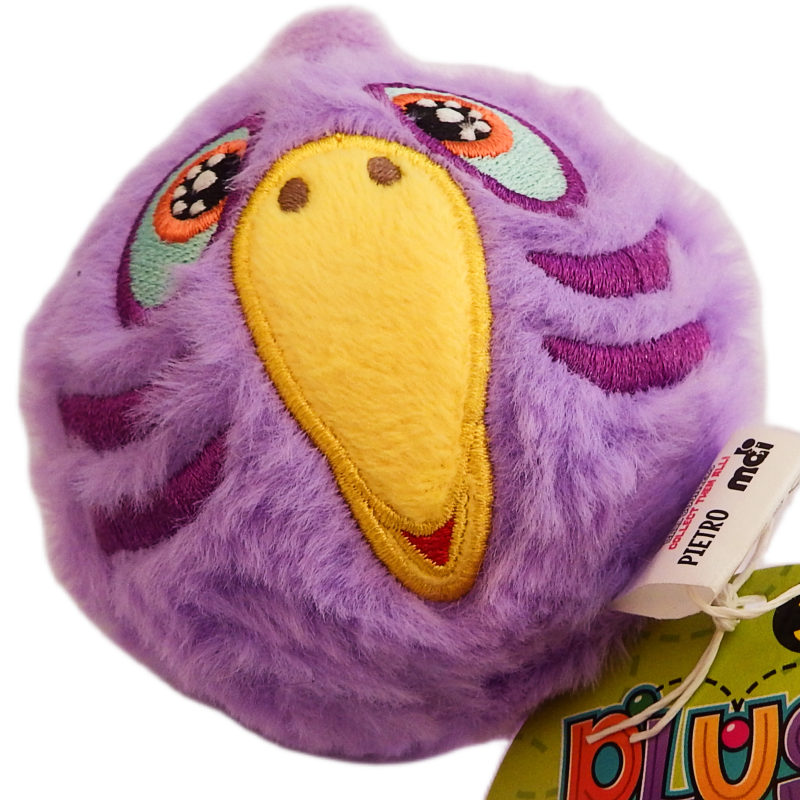 Purple plush toy with a yellow beak and colorful eyes on a white background
