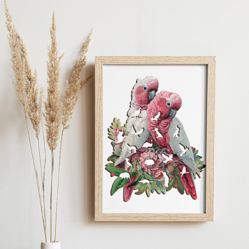 Framed artwork of two parrots on a white background with decorative elements.