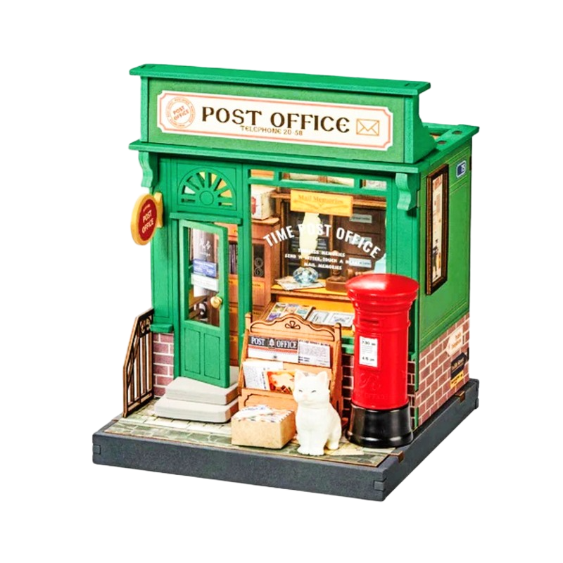 Model of a miniature post office with a green facade and red mailbox.