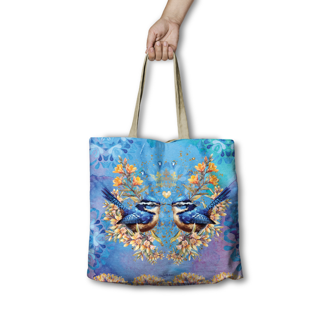 Tote bag with a design of two birds and floral elements on a blue background.