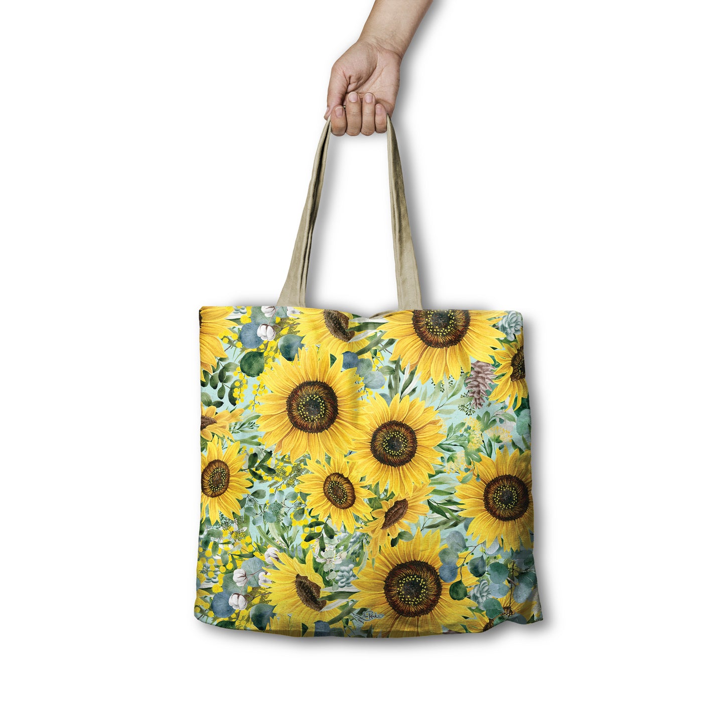 Tote bag with sunflower design held by a hand on a white background