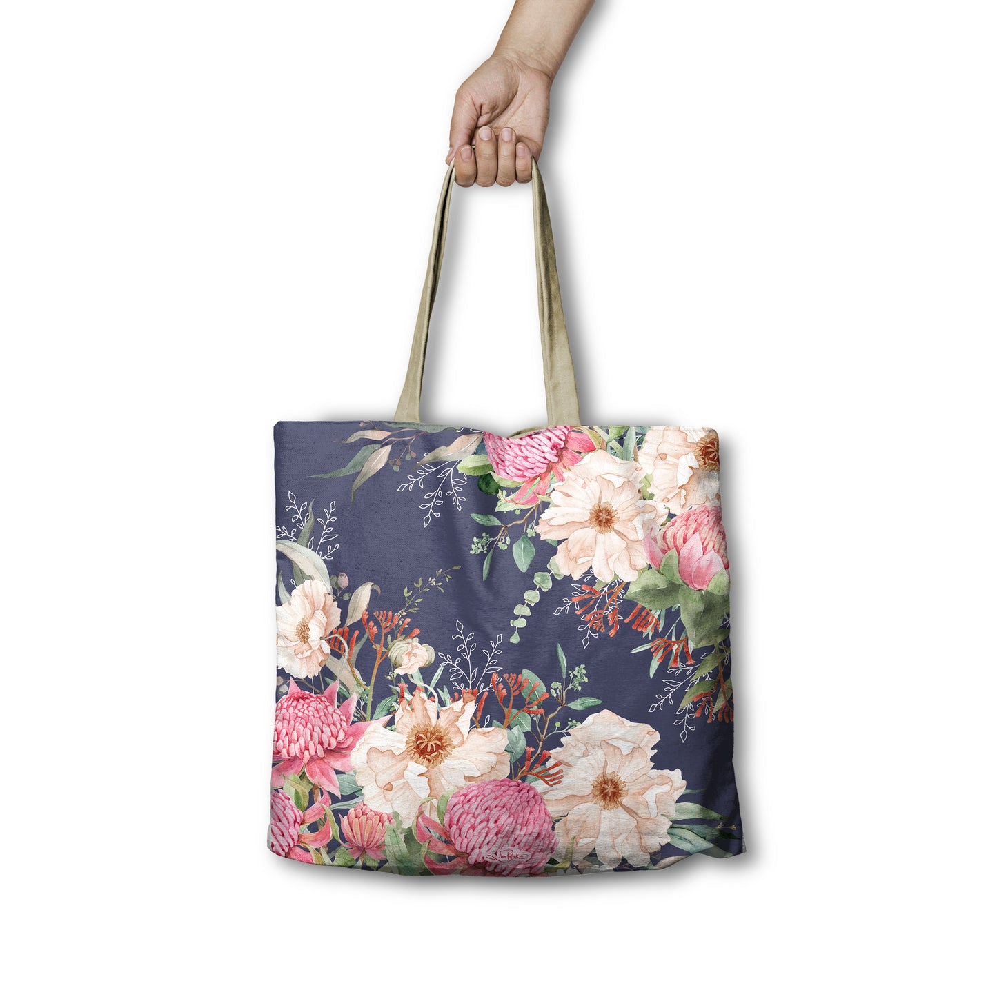 Floral tote bag held by a hand on a white background