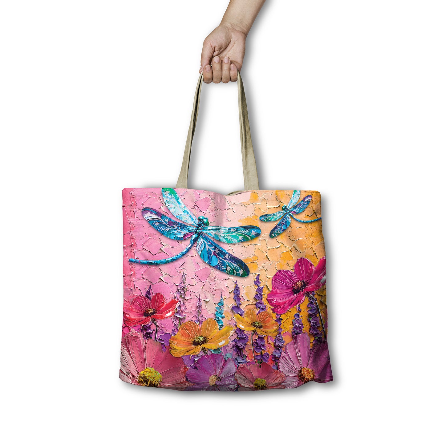Tote bag with floral and dragonfly design held by a hand on a white background