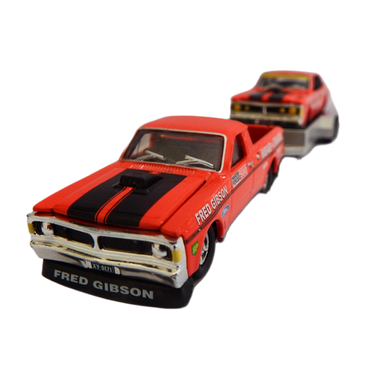 Red toy truck with black stripes and 'Fred Gibson' branding on a white background