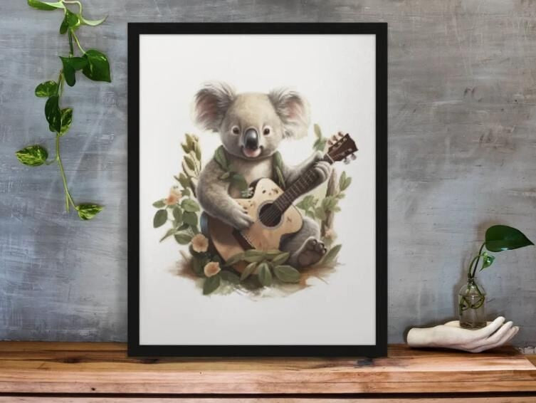 Framed artwork of a koala playing a guitar on a wooden surface with a gray wall background.