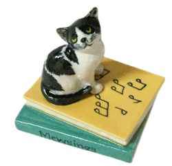 Cat sitting on music book Ceramic Miniature figurine