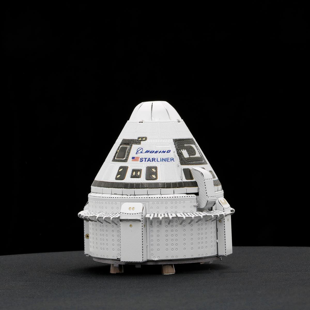 Model of Boeing Starliner spacecraft on a black background