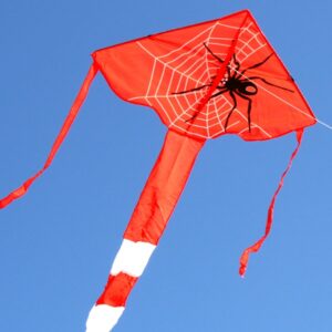 Red kite with spider design against a clear blue sky