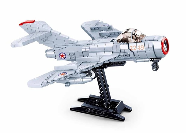 Model of a fighter jet on a stand with a white background