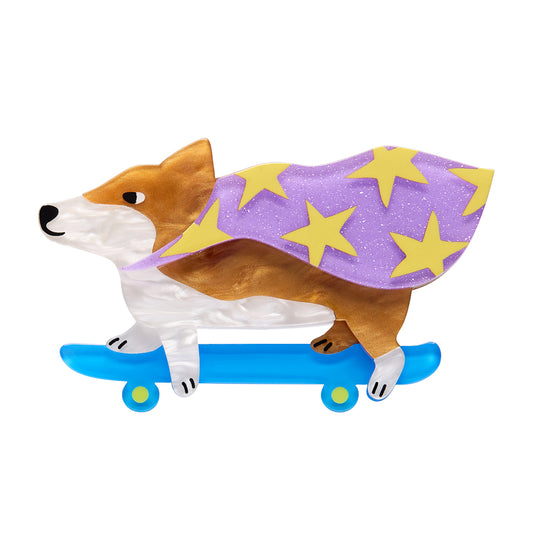 Erstwilder Brooch corgi design, purple cape with yellow stars, and blue skateboard on a white background