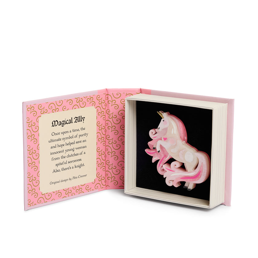 Pink unicorn figurine in a decorative box with text on a white background