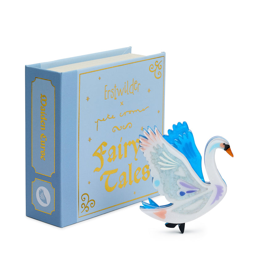 Blue book titled 'Fairy Tales' with a swan brooch illustration  on a white background