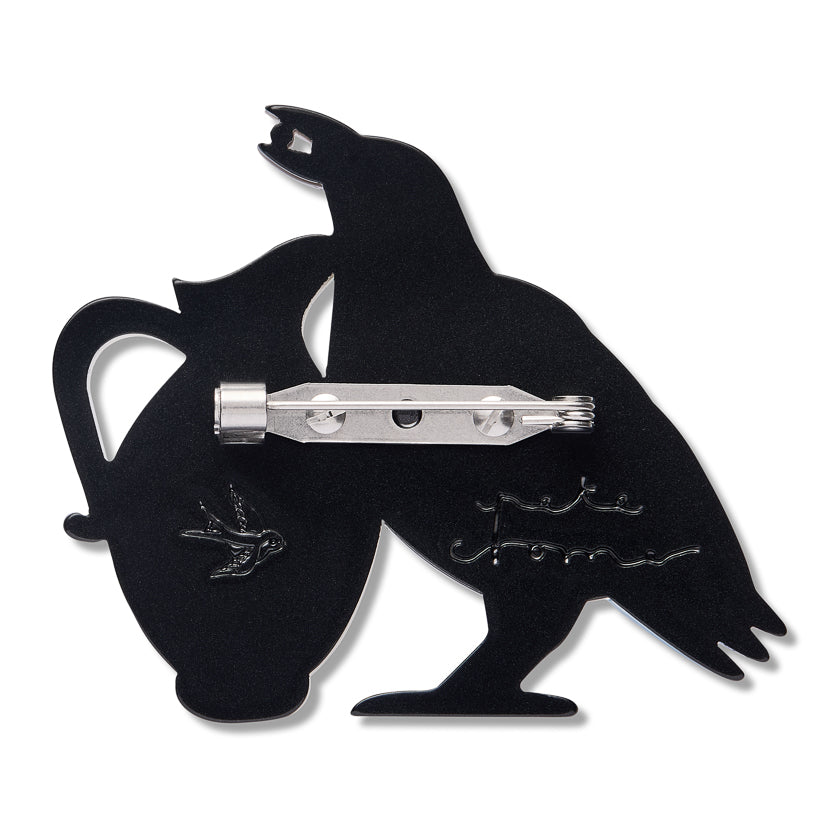 The Back of a Black bird-shaped brooch with Erstwilder logo and Pete Cromer signature embedded into the ack of brooch and stainless steel brooch fastner