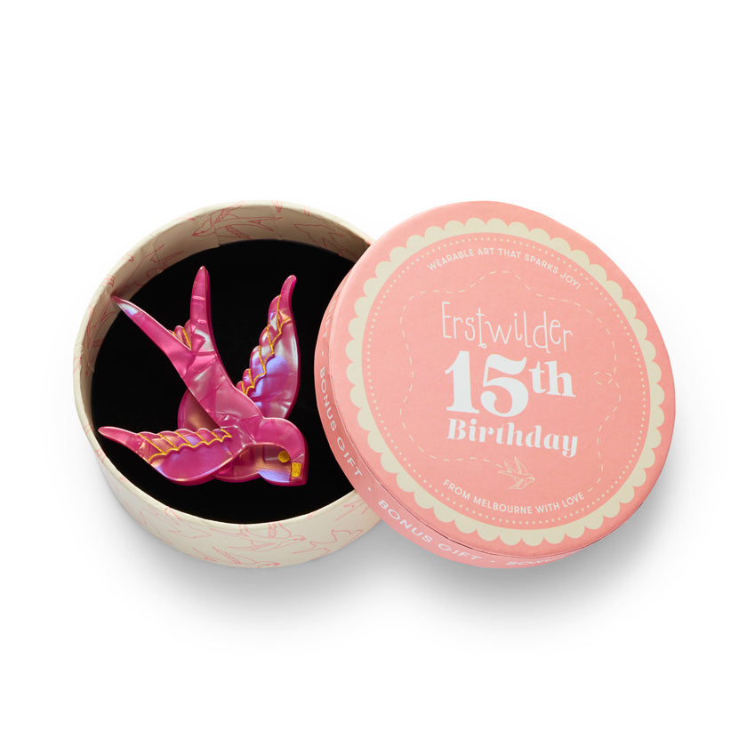 A pink swallow in a roundshaped keepsake box shown open with a matching pink lid beside it on a white background. The lid has white text reading 'Erstwilder 15th Birthday' and 'Fon Melbourne with Love.