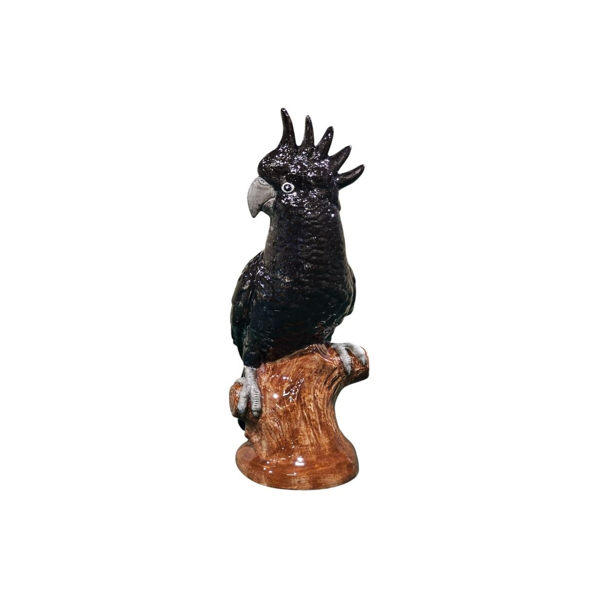 Black cockatoo figurine on a branch against a white background