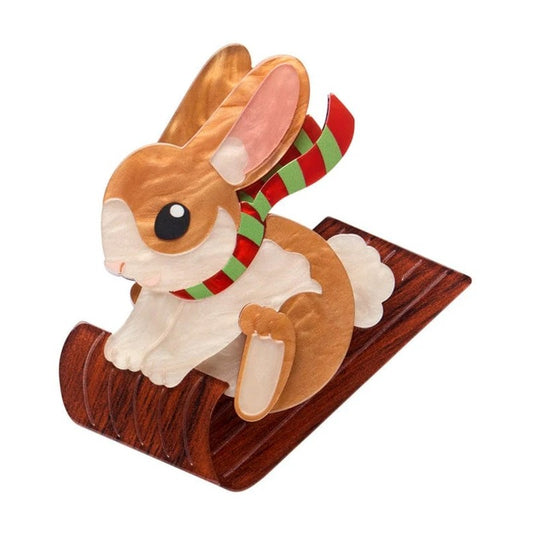 rabbit on Toboggan with a red and green striped scarf on a white background