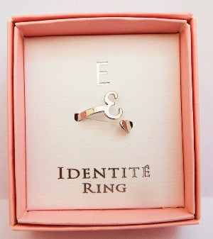 Ring with 'E design in a pink box labeled 'IDENTITE RING'.