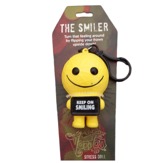 Yellow smiley face keychain with a tag on a branded packaging background