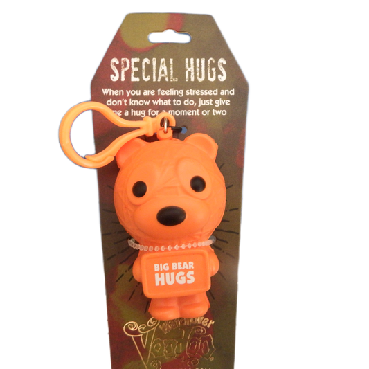 Orange bear-shaped keychain with 'Big Bear Hugs' text on a brown packaging background.