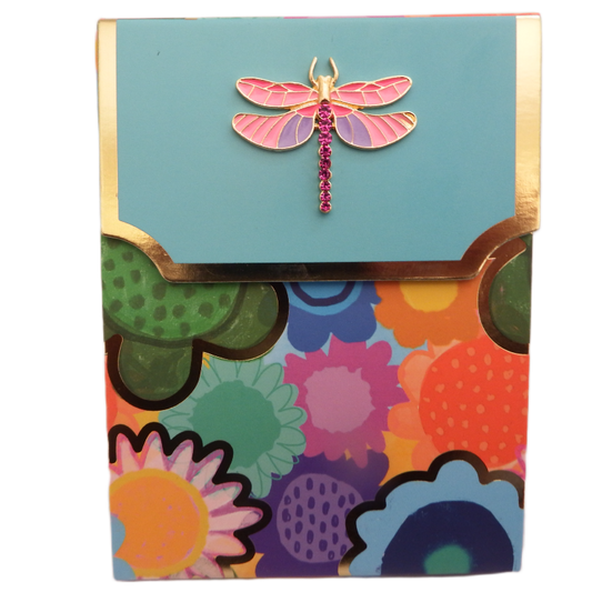 Colorful floral-patterned box with a pink dragonfly brooch on a light blue background