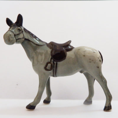 Model race horse with a saddle on a white background