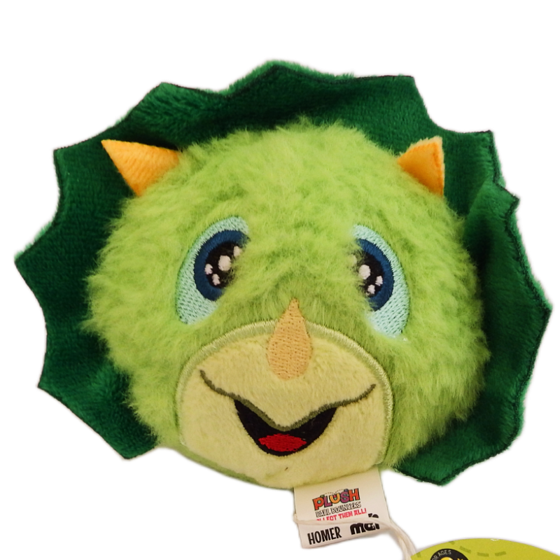 Green plush dinosaur toy with a tag on a white background