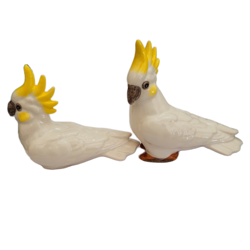 Set of Two ceramic yellow crested cockatoo figurines with yellow crests and yellow cheeks on a white background