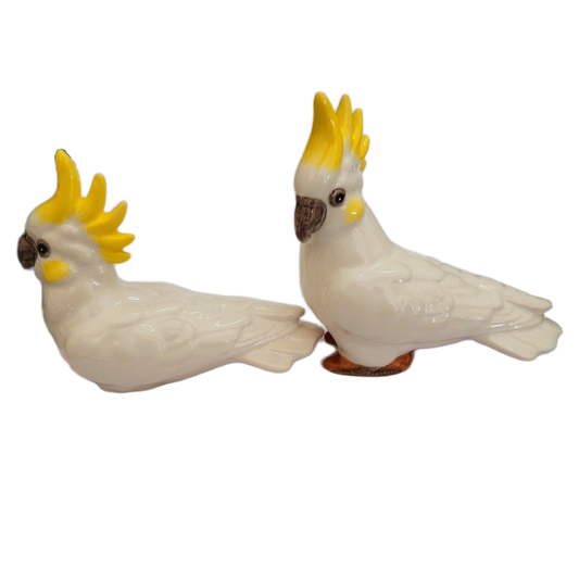 Set of Two ceramic yellow crested cockatoo figurines with yellow crests and yellow cheeks on a white background