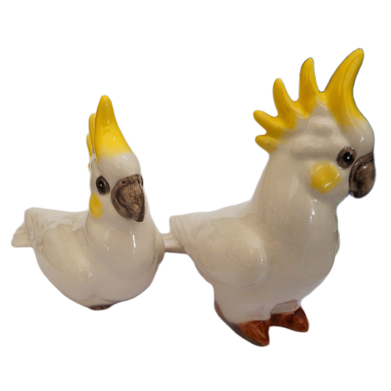 Two ceramic cockatoo figurines on a white background