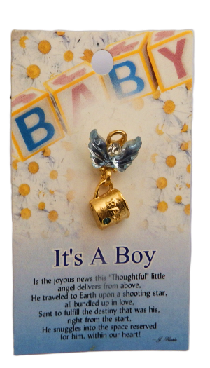 Gold mug with angel wings charm on a 'It's a Boy' card with baby-themed decorations.