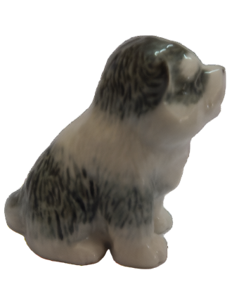 Small ceramic  Alaskan Malimute puppy dog figurine on a white background