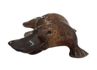 Brown ceramic platypus figurine on a white background