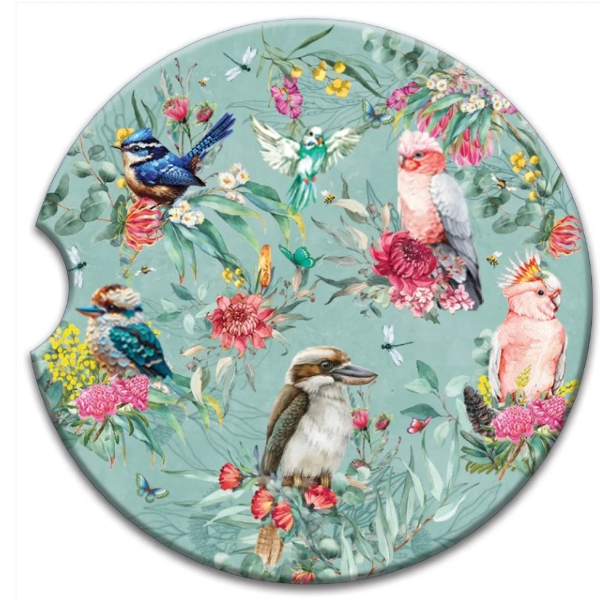 A round coaster featuring a detailed nature illustration print with kookaburras, cockatoos, a bluebird, a fairybird, and pink flowers on a dusty teal-green background.