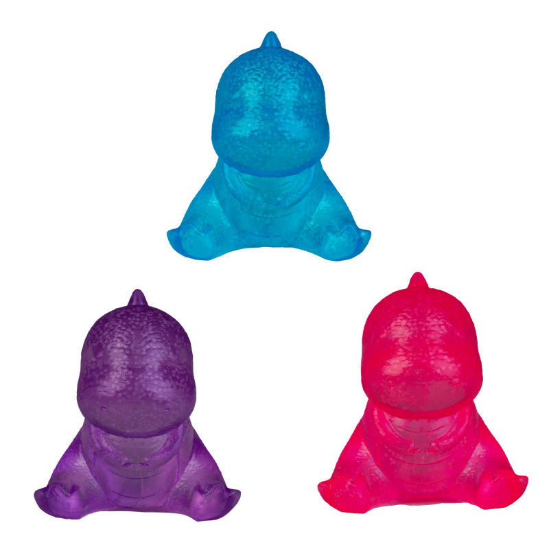 Three small dinosaur-shaped bath or body toys in bright blue, purple, and hot pink, arranged on a plain white background.