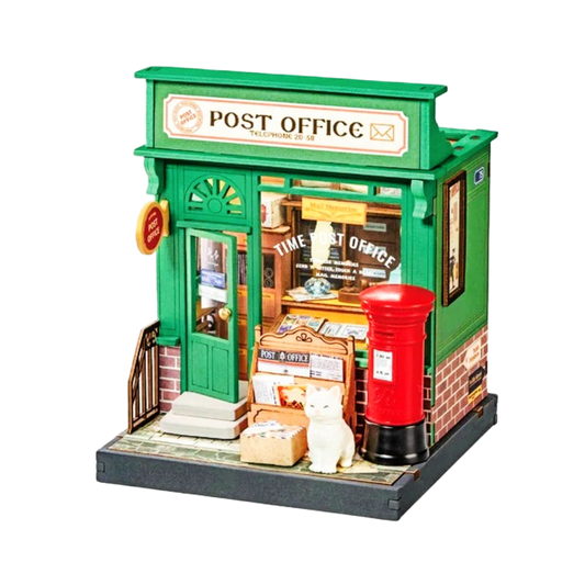 Model of a miniature post office with a green facade and red mailbox.