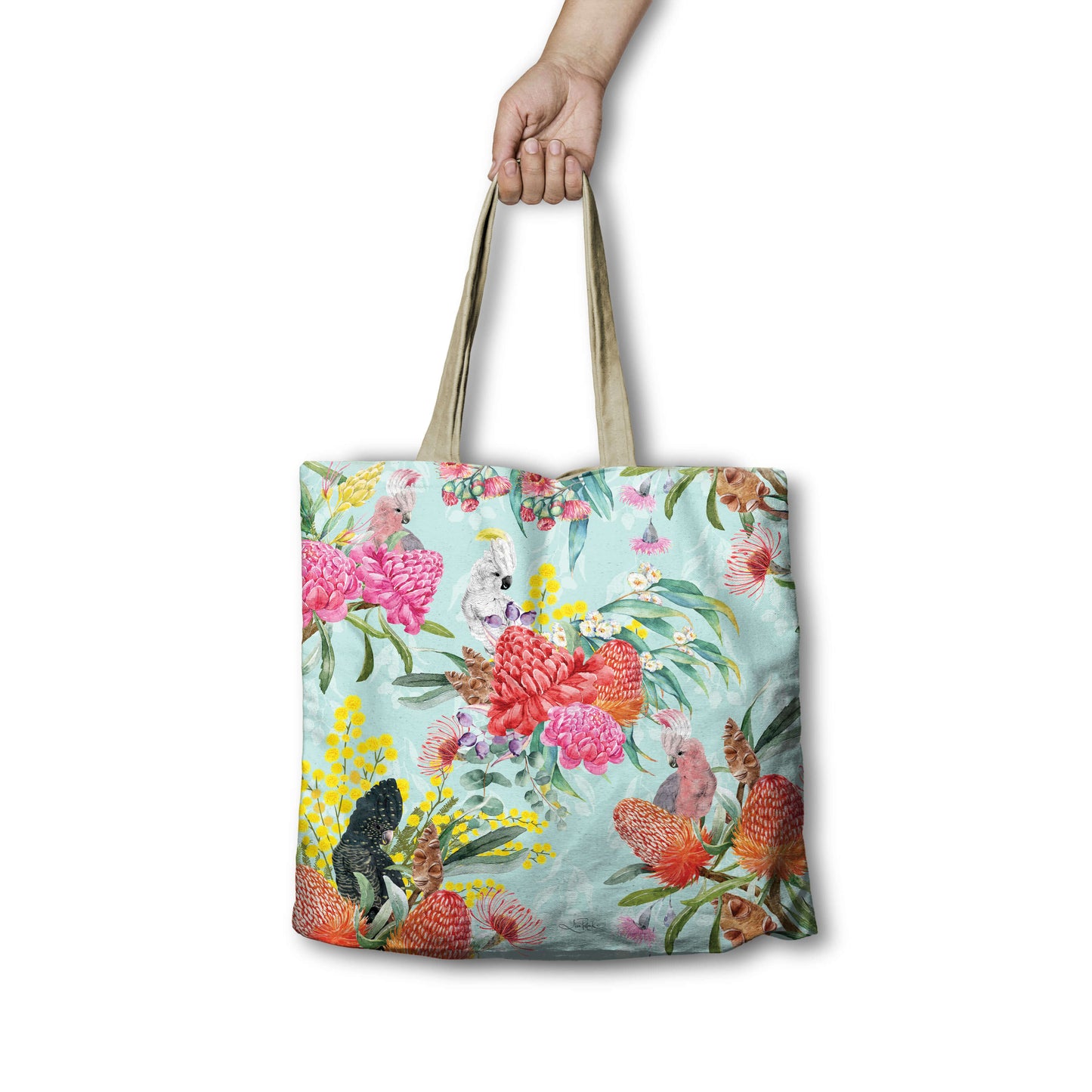 Tote bag with floral design held by a hand on a white background