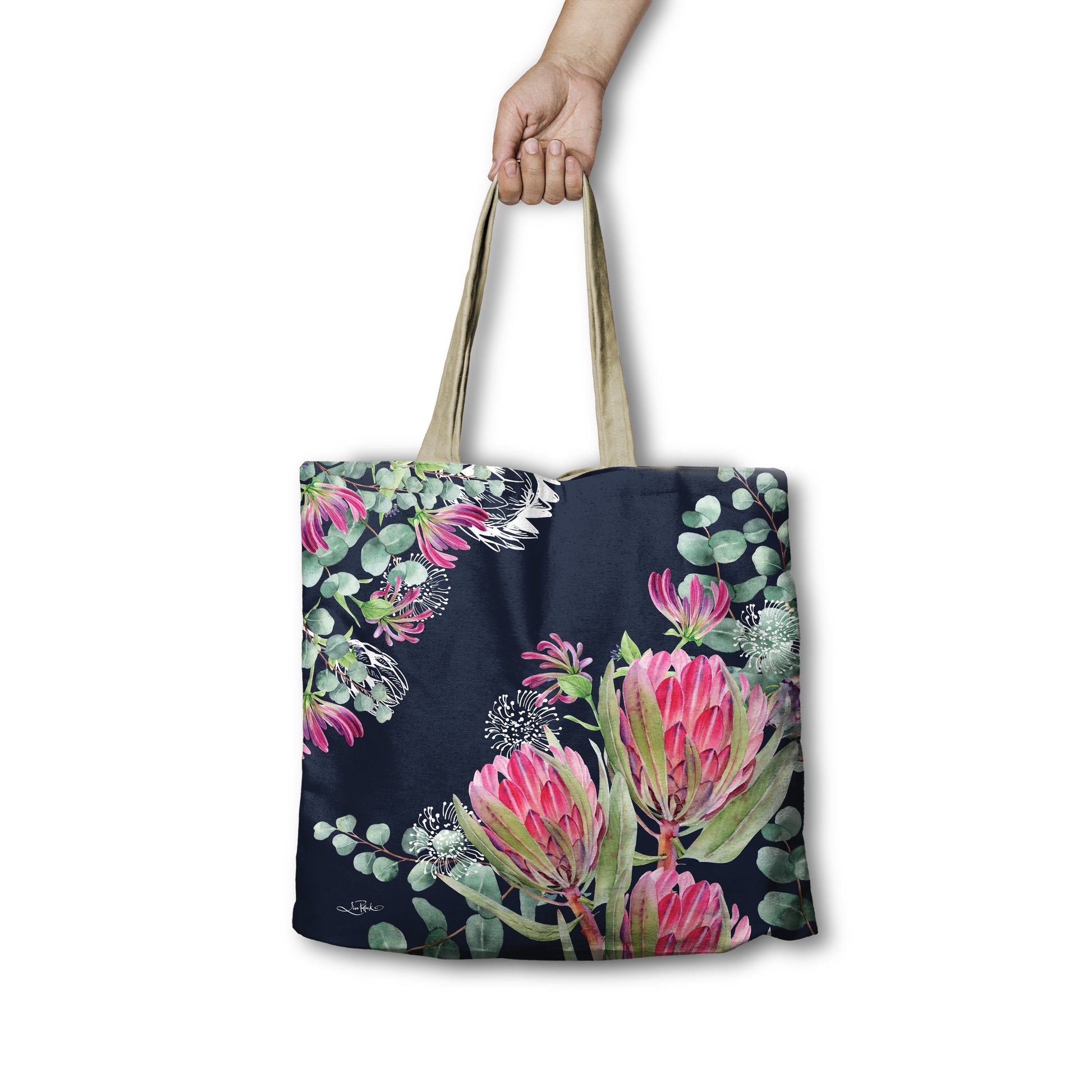 Tote bag with floral design held by a hand on a white background