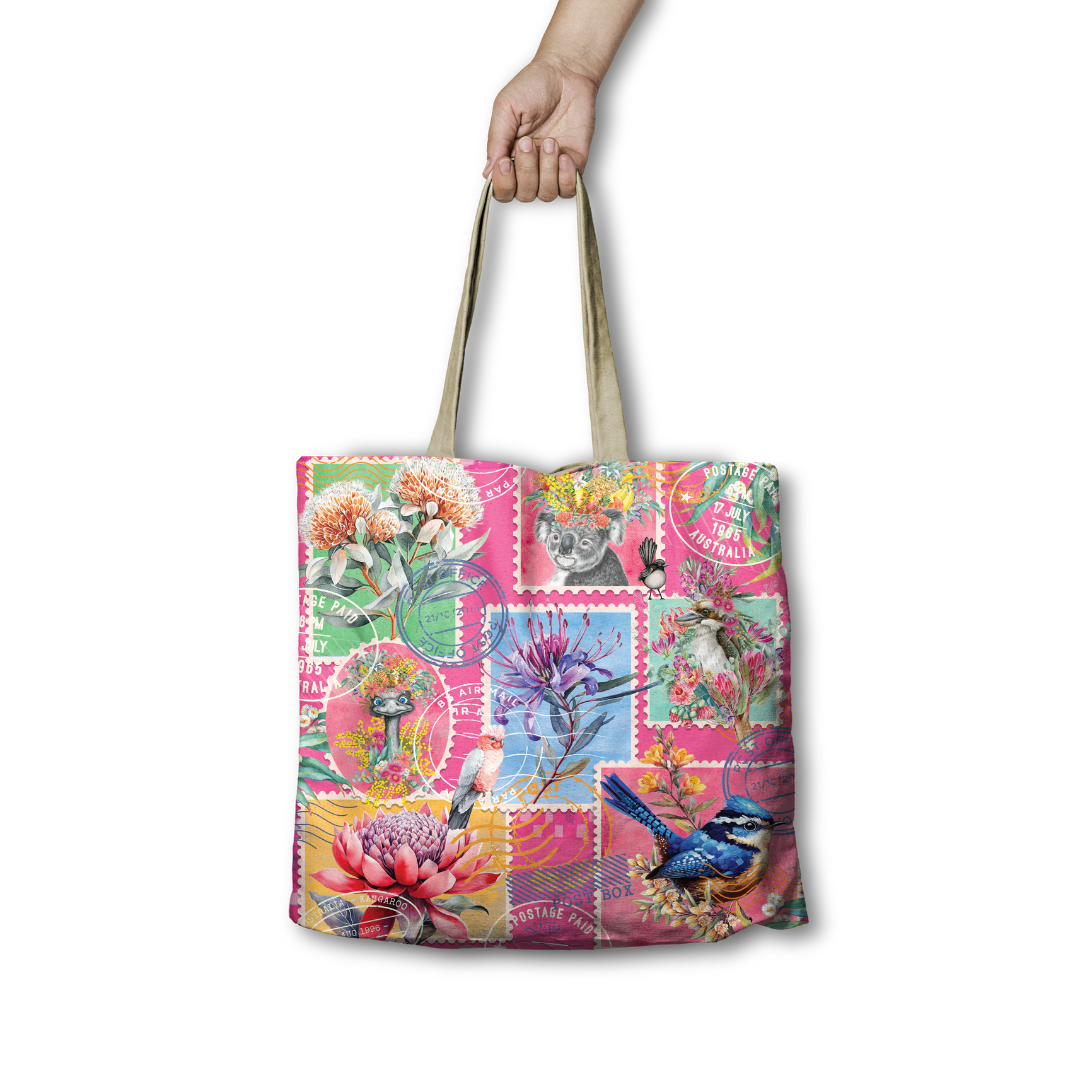 Tote bag with colorful patchwork stamp design featuring flowers and birds, held by a hand on a white background.
