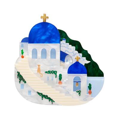 Decorative erstwilder brooch with a blue-domed church design on a white background