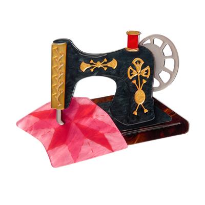 Decorative sewing machine illustration with pink fabric on a white background